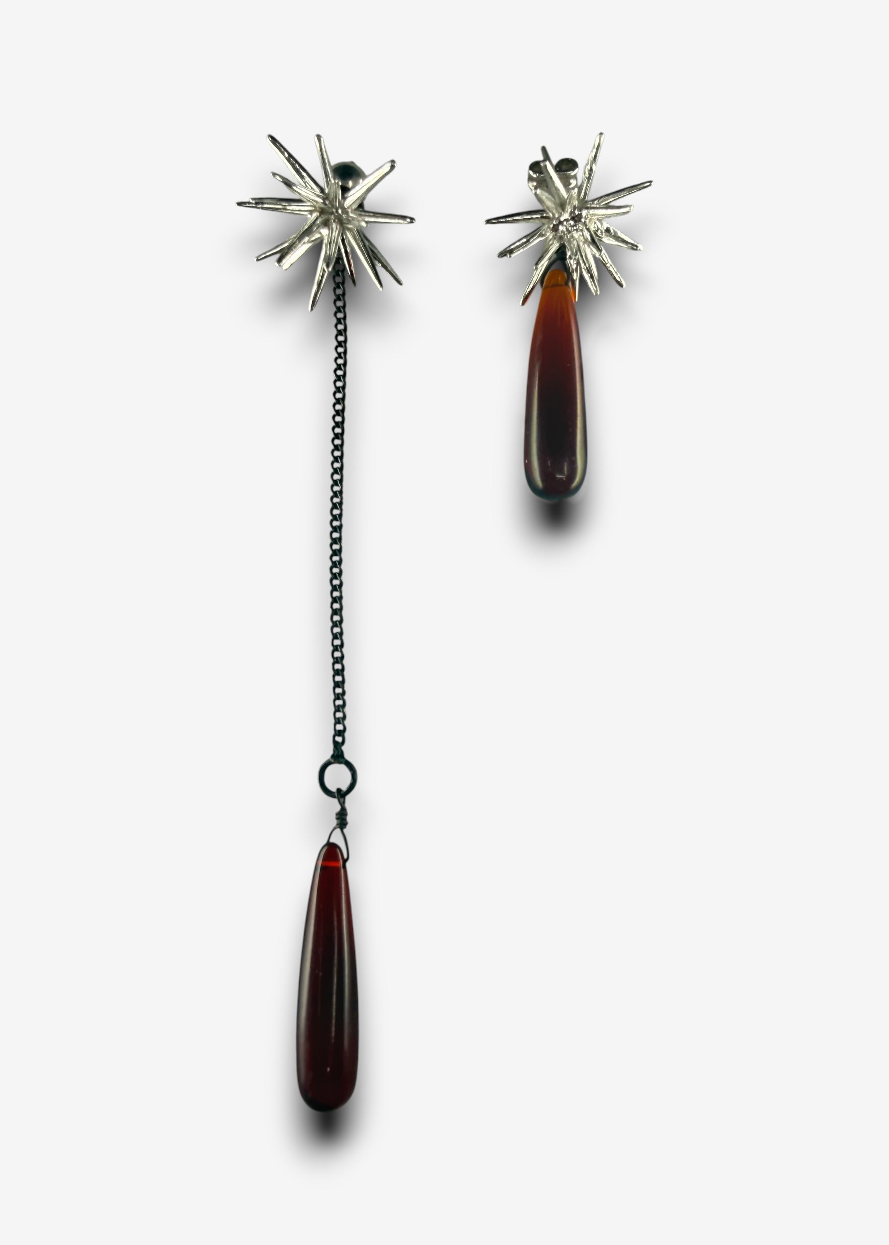 Asymmetrical Beam earrings with one long chain drop and ruby quartz pendant and one shorter ruby quartz drop attached to silver spike studs