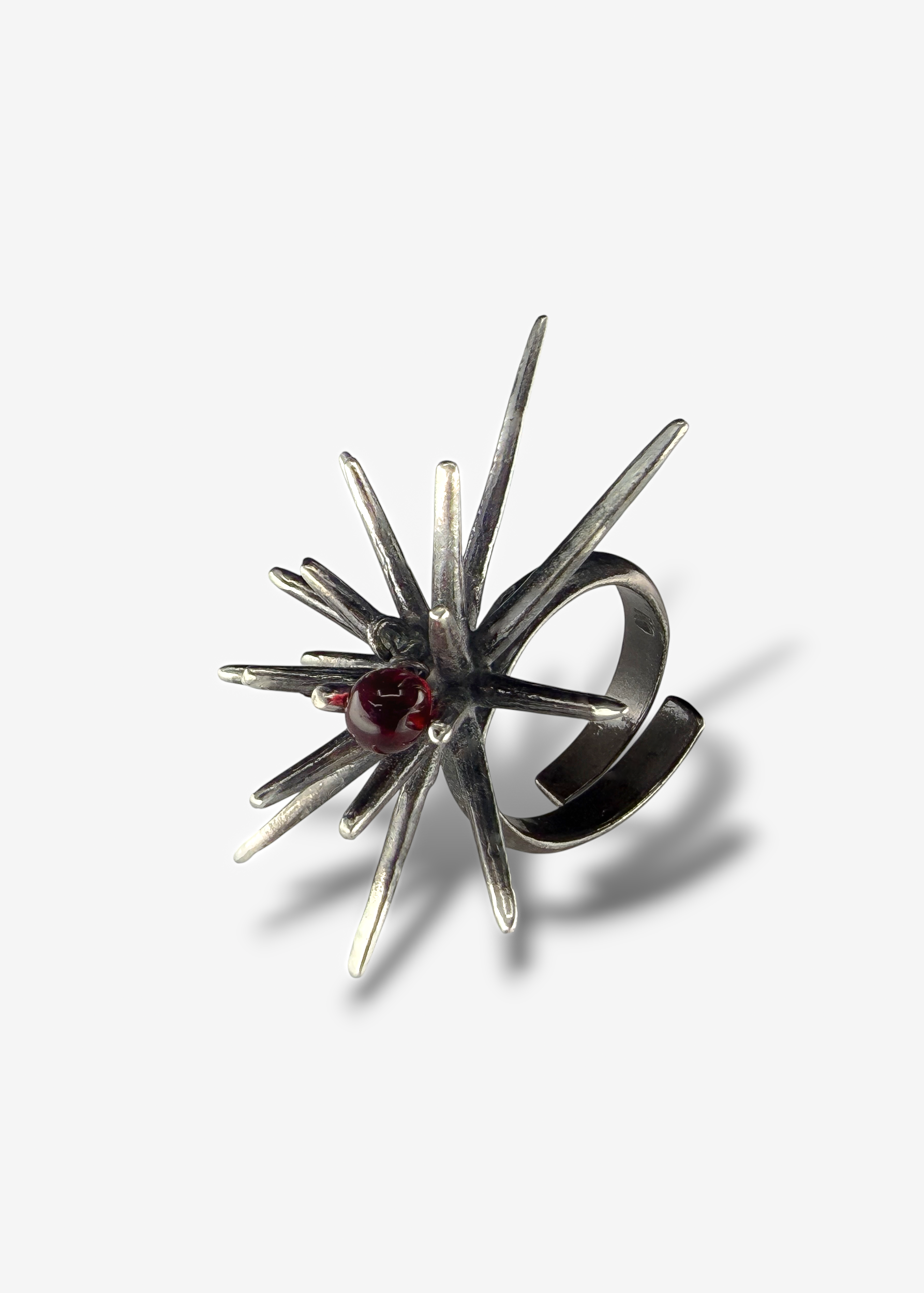 Sterling silver Beam Afterlight ring with dark patina finish and moving red Czech crystal worn on hand, sculptural spiked statement ring