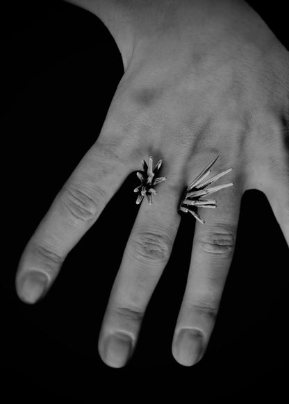 close up of hand wearing sculptural spike ring with sharp protruding forms in black and white