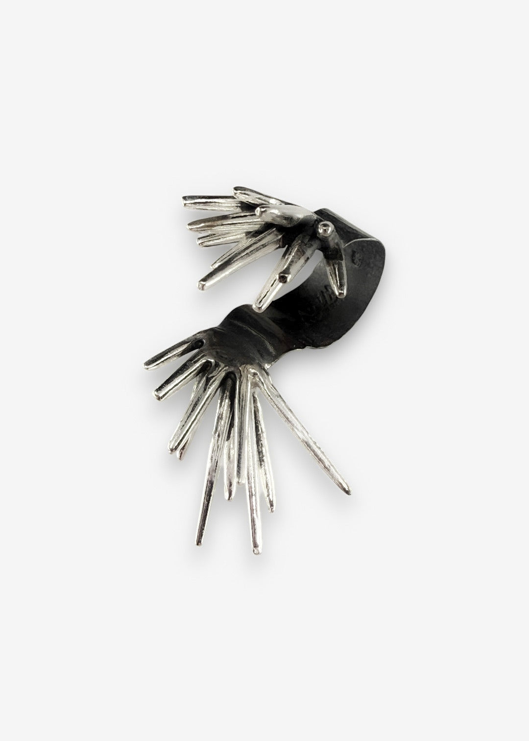 angled view of sterling silver sculptural spike ring showing two opposing forms with open space between