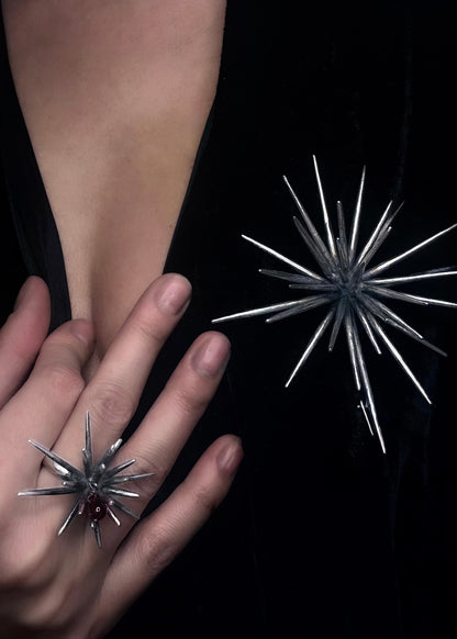 Close-up of handcrafted silver brooch and matching spike ring worn on body, sculptural jewelry by Ninimosi