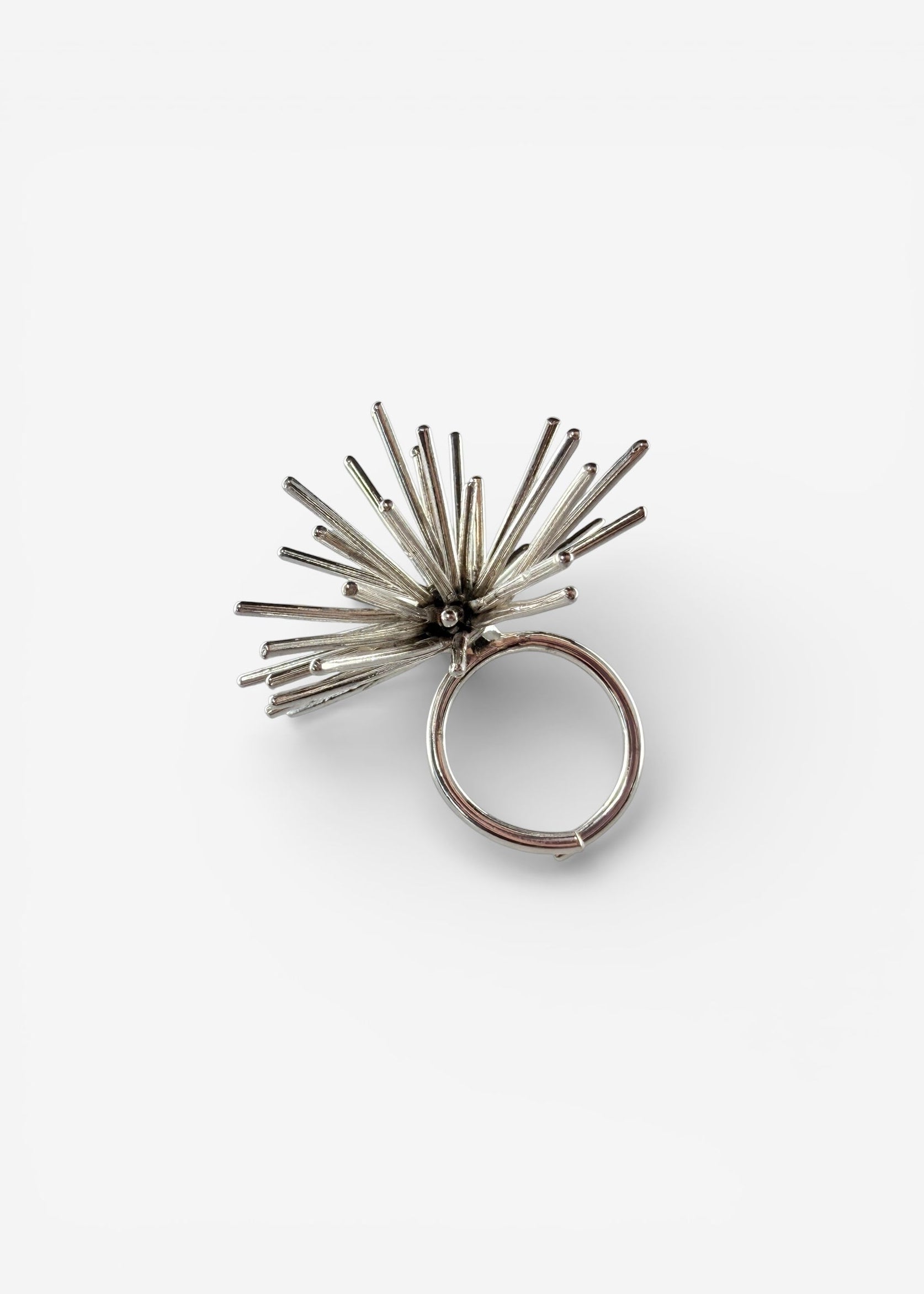 Handmade sterling silver Beam ring by Ninimosi, sculptural spike design with visible adjustable band on white background