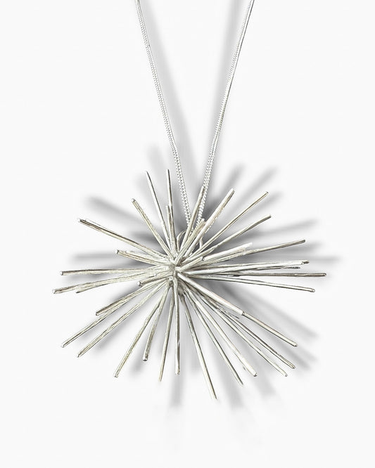 Handmade sterling silver Beam necklace by Ninimosi, sculptural starburst pendant on chain, minimalist white background