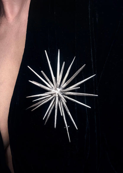 Large sterling silver statement brooch worn on black garment, sculptural spike design by Ninimosi
