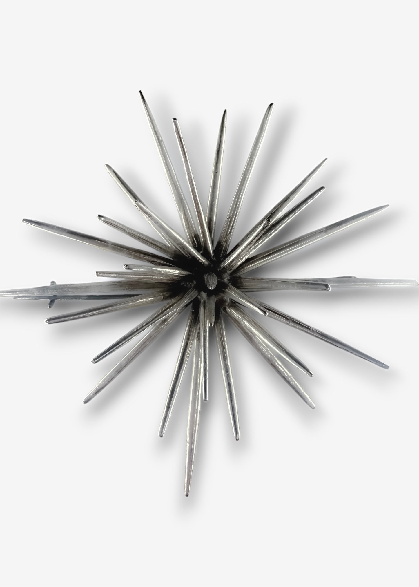 Handmade sterling silver sculptural brooch by Ninimosi, asymmetrical spike design on white background