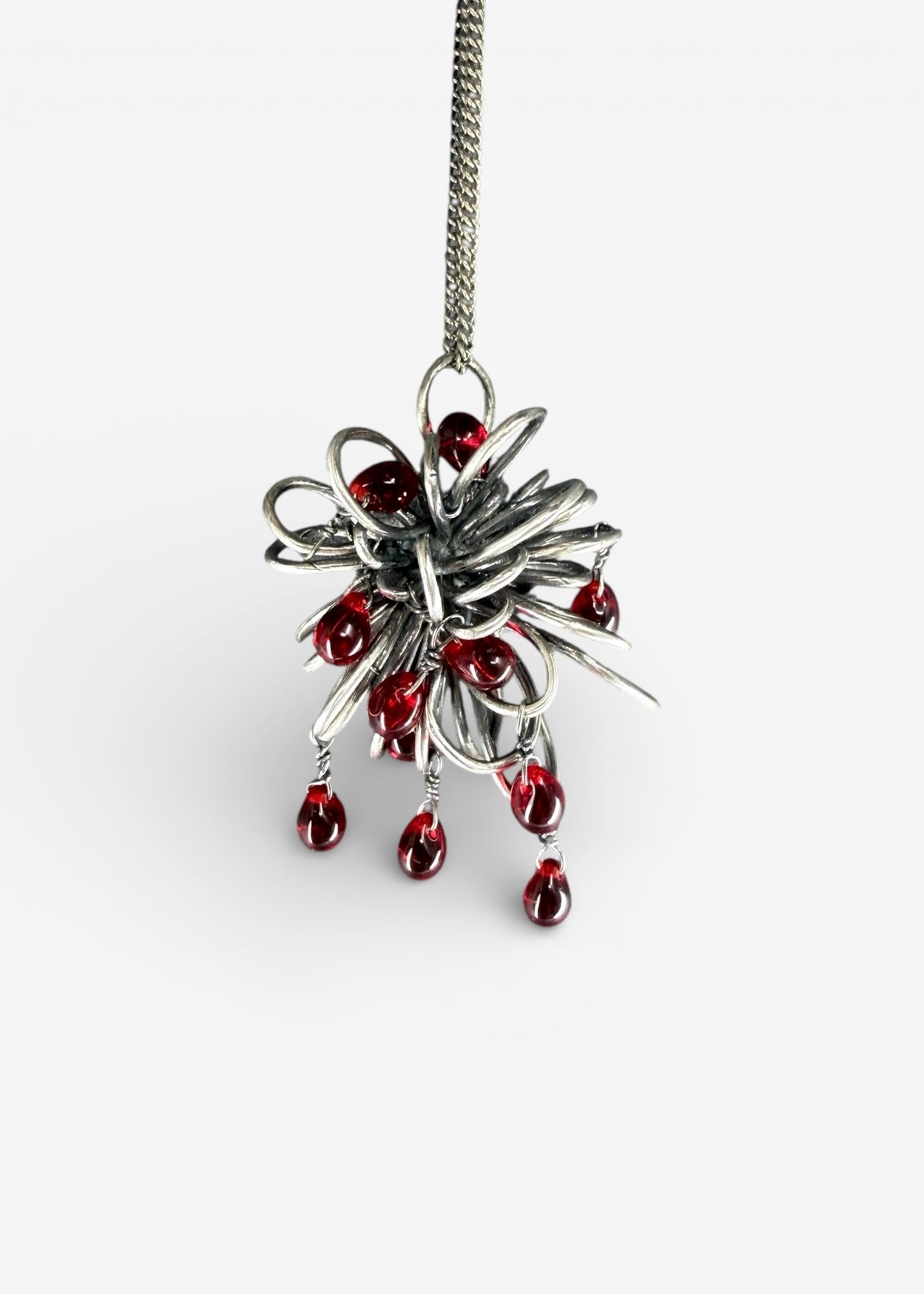Sterling silver Inversion necklace pendant with dense folded beam structure and multiple dangling red Czech glass drops on chain