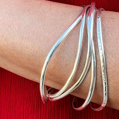 Stack of handmade silver bracelets
