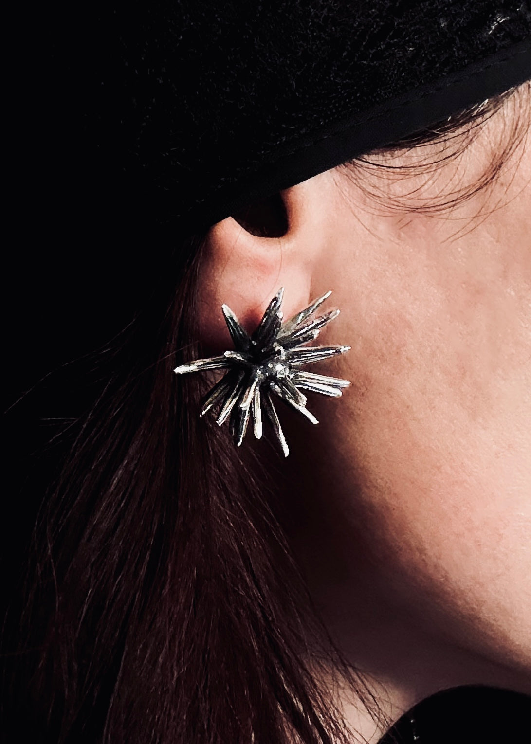 Handmade sterling silver Beam stud earring by Ninimosi worn on ear, bold sculptural spike design in close-up