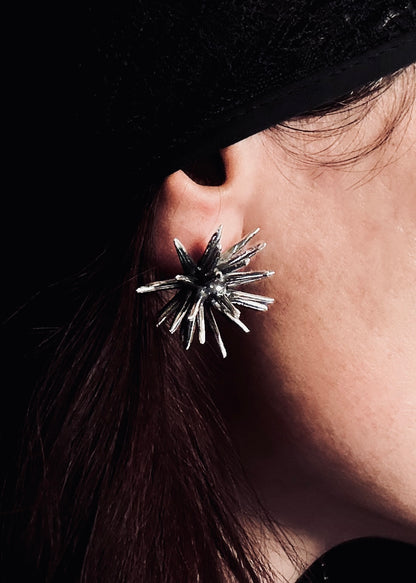 Handmade sterling silver Beam stud earring by Ninimosi worn on ear, bold sculptural spike design in close-up