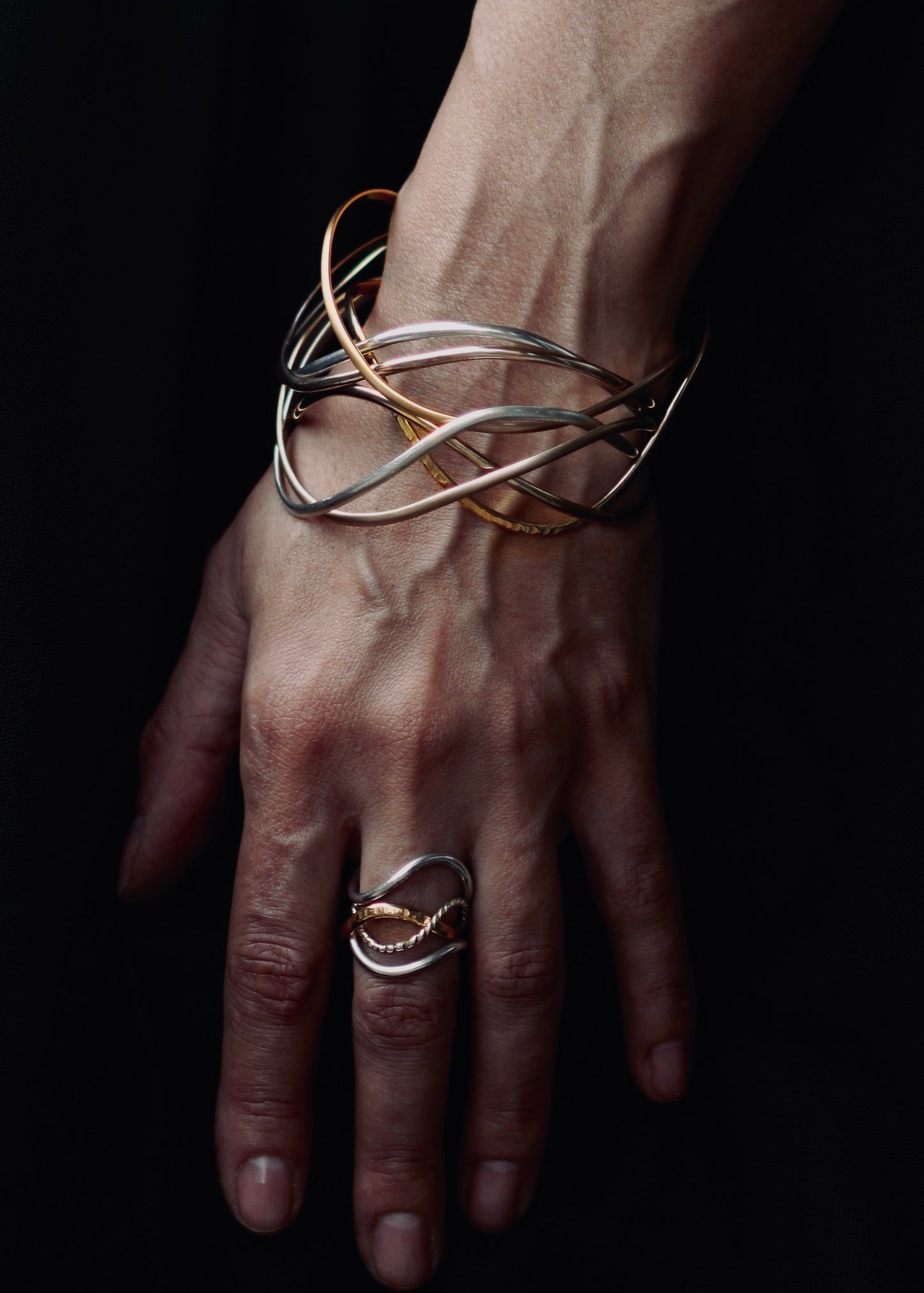Gold and Silver bangle stack on wrist, handcrafted sculptural bangles, elegan stackable jewelry