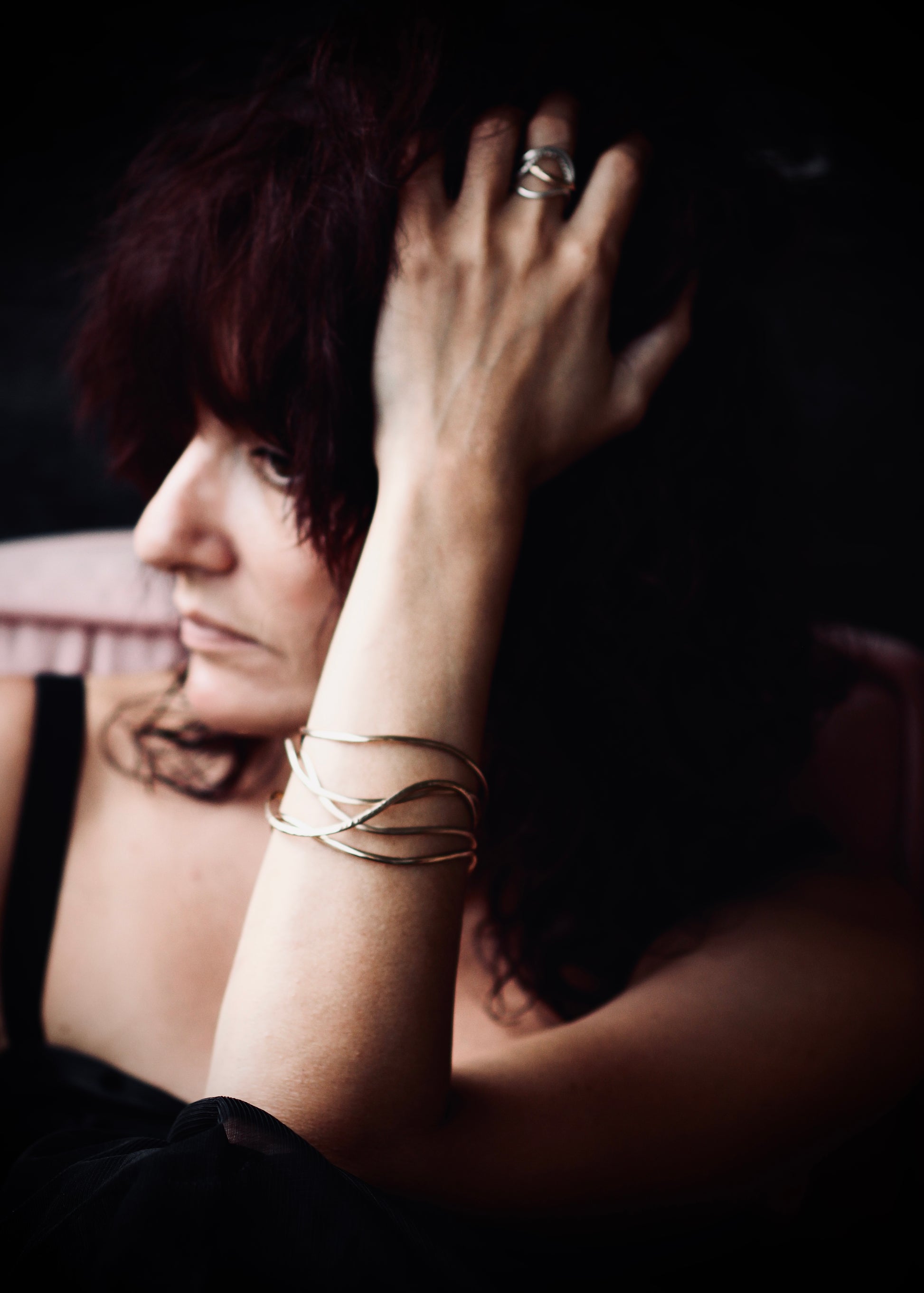 Gold wave bangle stack on wrist, handcrafted sculptural bangles worn in lifestyle portrait
