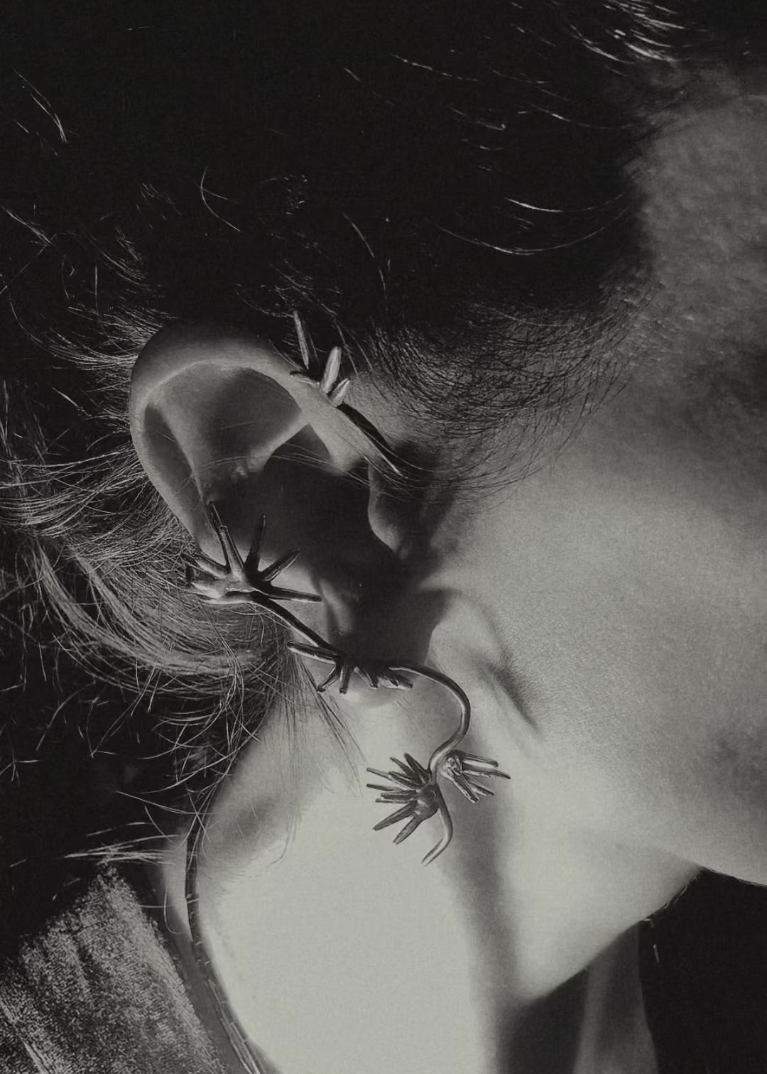 Sterling silver spike ear cuff wrapping along ear sculptural design Beam Collection close up on ear